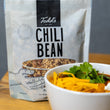 Load image into Gallery viewer, Todd's Chili Bean package with a bowl of chili and tortilla chips on a wooden surface
